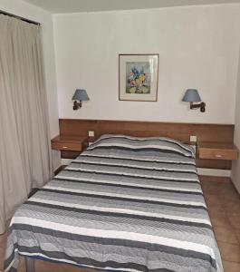 a bed in a bedroom with two lamps on the wall at La Pointe de Sel - Plage a 2 minutes a pied in Lumio