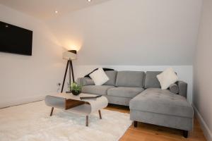 a living room with a couch and a table at Penthouse at the White House near Edinburgh in Bathgate