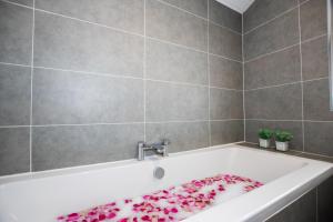 a bathroom with a bath tub with a towel on it at Penthouse at the White House near Edinburgh in Bathgate +58 photos
