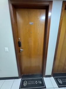 een houten deur met een bord ervoor bij Apto moderno, aconchegante e bem localizado, próximo a P Federal, ENAP, LBV, Aeroporto na Asa Sul - Brasília in Brasilia +14 foto's