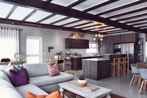 a living room with a couch and a kitchen at Palm Villa Beachfront Accomodation in Hentiesbaai