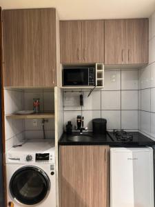 een keuken met een wasmachine en een magnetron bij Apto moderno, aconchegante e bem localizado, próximo a P Federal, ENAP, LBV, Aeroporto na Asa Sul - Brasília in Brasilia