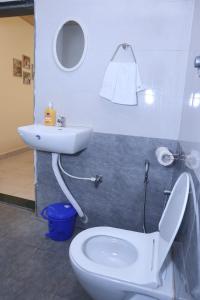 a bathroom with a white toilet and a sink at Keshav Villa Sea View Holiday Home in Jāmb