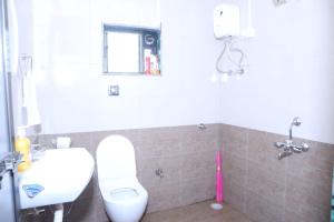 a bathroom with a white toilet and a sink at Keshav Villa Sea View Holiday Home in Jāmb +6 photos