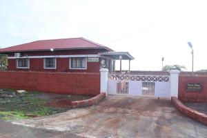 a red brick house with a white fence at Keshav Villa Sea View Holiday Home in Jāmb