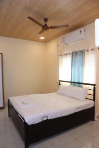 a bedroom with a bed with a ceiling fan at Keshav Villa Sea View Holiday Home in Jāmb