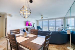 a living room with a table and a blue couch at New Smyrna Beachfront Modern 9th Floor Condo Pool Hot Tub in New Smyrna Beach