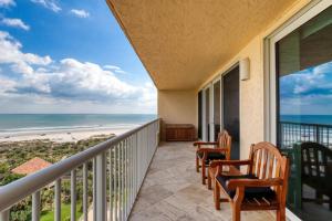 a balcony with chairs and a view of the beach at New Smyrna Beachfront Modern 9th Floor Condo Pool Hot Tub in New Smyrna Beach