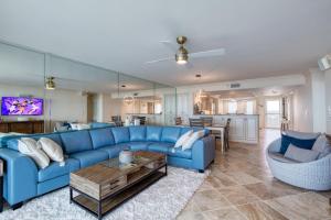 a living room with a blue couch and a table at New Smyrna Beachfront Modern 9th Floor Condo Pool Hot Tub in New Smyrna Beach +56 photos