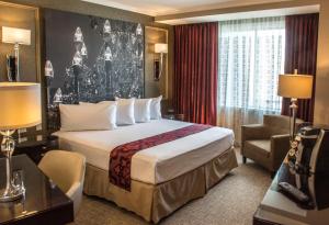 a hotel room with a large bed and a chair at The Delavan Hotel in Buffalo