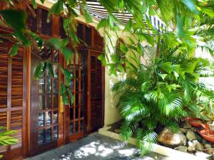 a building with wooden doors and a palm tree at Canario Boutique Hotel in San Juan