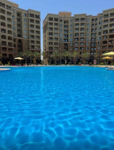 a large swimming pool in front of buildings at قريه اكوا فيو الساحل الشمالي العلمين in El Alamein