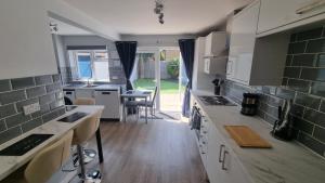 a kitchen with white cabinets and a counter top at Spencer , 4 bed slp 8 semi in Lee On The Solent in Lee-on-the-Solent