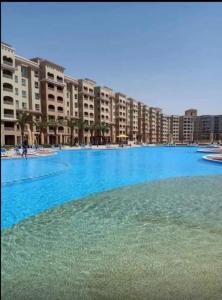 a large blue swimming pool in a resort at قريه اكوا فيو الساحل الشمالي العلمين in El Alamein