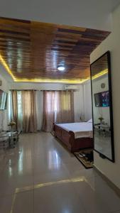 Un dormitorio con una cama y un espejo en la pared. en MB Suite Cogefar, en Douala