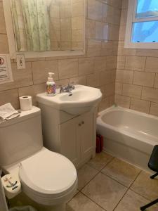 a bathroom with a toilet and a sink and a tub at Montreal Downtown Private Room in Montreal