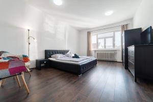 a bedroom with a bed and a dresser and a window at No8 Spacious City Center Apartment in Bratislava