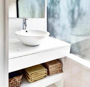 a white bathroom with a sink and some towels at Glamping Algarve Olive Tree Lodge in Nora