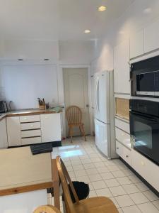 a kitchen with white appliances and a table and a table sidx sidx at Montreal Downtown Private Room in Montreal