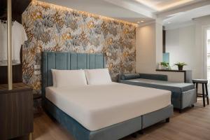 a bedroom with a large bed and a couch at Hotel Grazia Riccione in Riccione