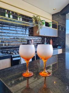 two wine glasses sitting on a counter in a kitchen at Casa Moderna com Itens de Lazer in Suzano