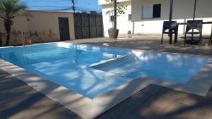 a swimming pool with blue water in a backyard at Casa Moderna com Itens de Lazer in Suzano