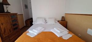 a bedroom with a bed with white towels on it at El Chozo in La Pinilla