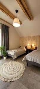a bedroom with two beds and a rug at Stara Szafa - Komfortowy dom nad jeziorem in Łajs