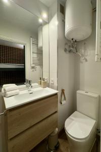 a bathroom with a toilet and a sink and a mirror at El Chozo in La Pinilla