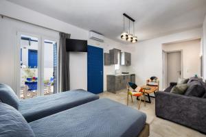a bedroom with a bed and a couch and a kitchen at Honeymoon Beach Studios in Perivolos