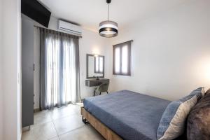 a bedroom with a bed and a desk in it at Honeymoon Beach Studios in Perivolos