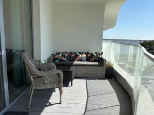 balkon z 2 krzesłami i kanapą w budynku w obiekcie LUX Apartament Rogowo Pearl w Rogowie