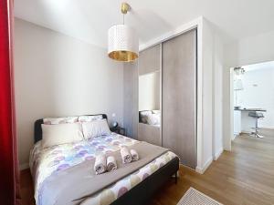 a bedroom with a bed with shoes on it at Appartement de charme Erdizka classé 3 étoiles in Bayonne