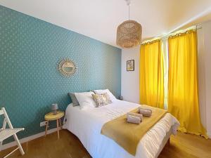 a bedroom with a bed and a yellow wall at Appartement de charme Erdizka classé 3 étoiles in Bayonne