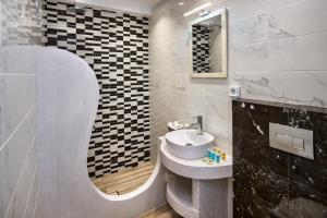 a bathroom with a sink and a mirror at Honeymoon Beach Studios in Perivolos