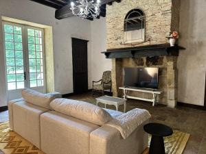 a living room with a couch and a fireplace at Domaine du Cèdre Eternel in Saint-Colomb-de-Lauzun