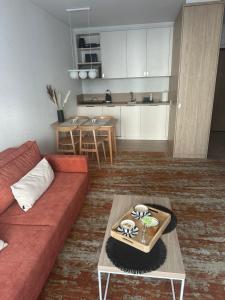 a living room with a red couch and a table at Belmare Bursztynowy Zakątek in Międzyzdroje