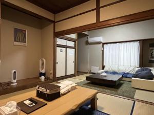 a living room with a bed and a table at Irest Village Matsumoto in Matsumoto