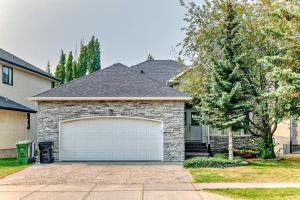 a house with a white garage door in a yard at Cozy bedroom in quiet community in Calgary