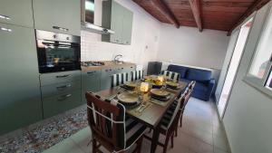 a kitchen with a table and chairs and a kitchen with a table and chairsktop at Casa Nonna Rosa in Balestrate