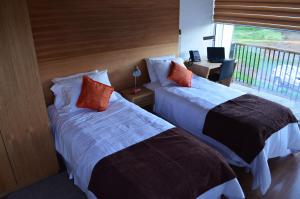 Cette chambre dispose de deux lits et d'un balcon. dans l'établissement Ruta Hotel Alto La Cruz, à Los Ángeles