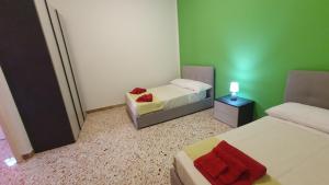 a small room with two beds and a lamp on a table at Casa Nonna Rosa in Balestrate