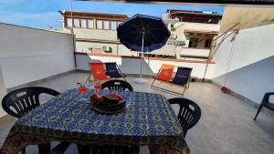 a table and chairs with an umbrella on a balcony at Casa Nonna Rosa in Balestrate +17 photos