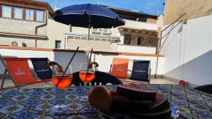 a table with an umbrella and a plate of food at Casa Nonna Rosa in Balestrate