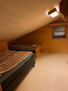 an attic room with two beds and a window at Rolig sted med fantastisk utsikt in Longyearbyen