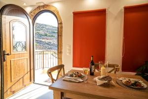 a dining room with a wooden table and a window at Tsolias Stone House 2 in Palekastron