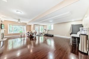 an empty living room with a hard wood floor and a tv at Cozy bedroom in quiet community in Calgary