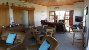 sala de estar con sillas de cuero y mesa en Oyster Catcher Stay And Explore, en Cape St. Francis