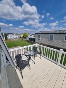 eine Terrasse mit zwei Stühlen und einem Tisch darauf in der Unterkunft A beautiful 4 birth - 714 Unity Beach Holiday Resort Unity 2 pets stay free in Brean