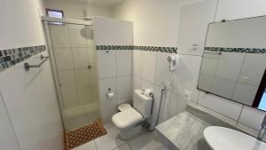 a bathroom with a shower and a toilet and a sink at Recanto da Praia Pousada in São Miguel do Gostoso +117 photos